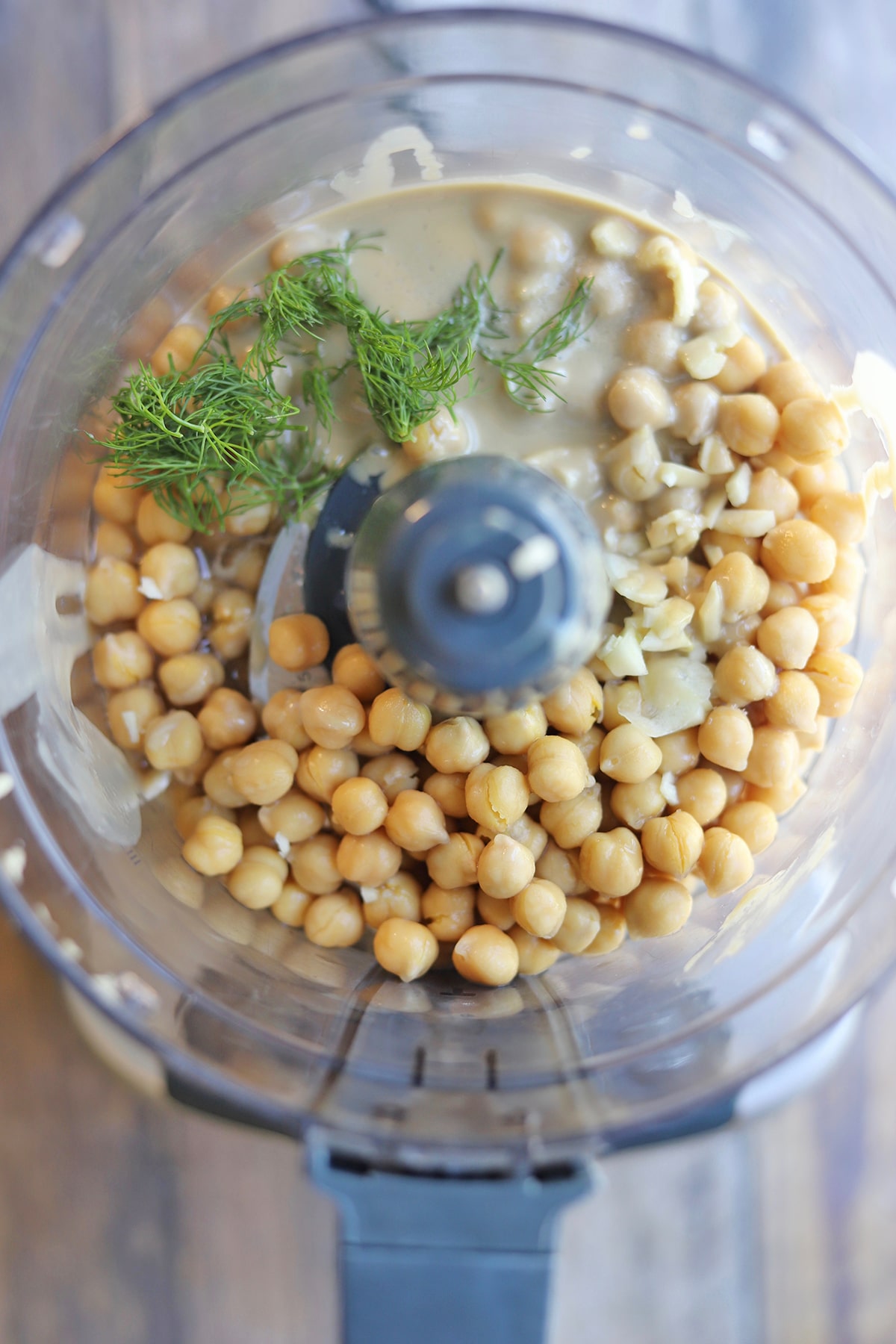 Chickpeas, tahini, dill, and garlic in food processor bowl.