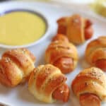 Text overlay: Vegan pigs in a blanket, air fryer or baked. Crescent dogs on platter with dipping sauce.
