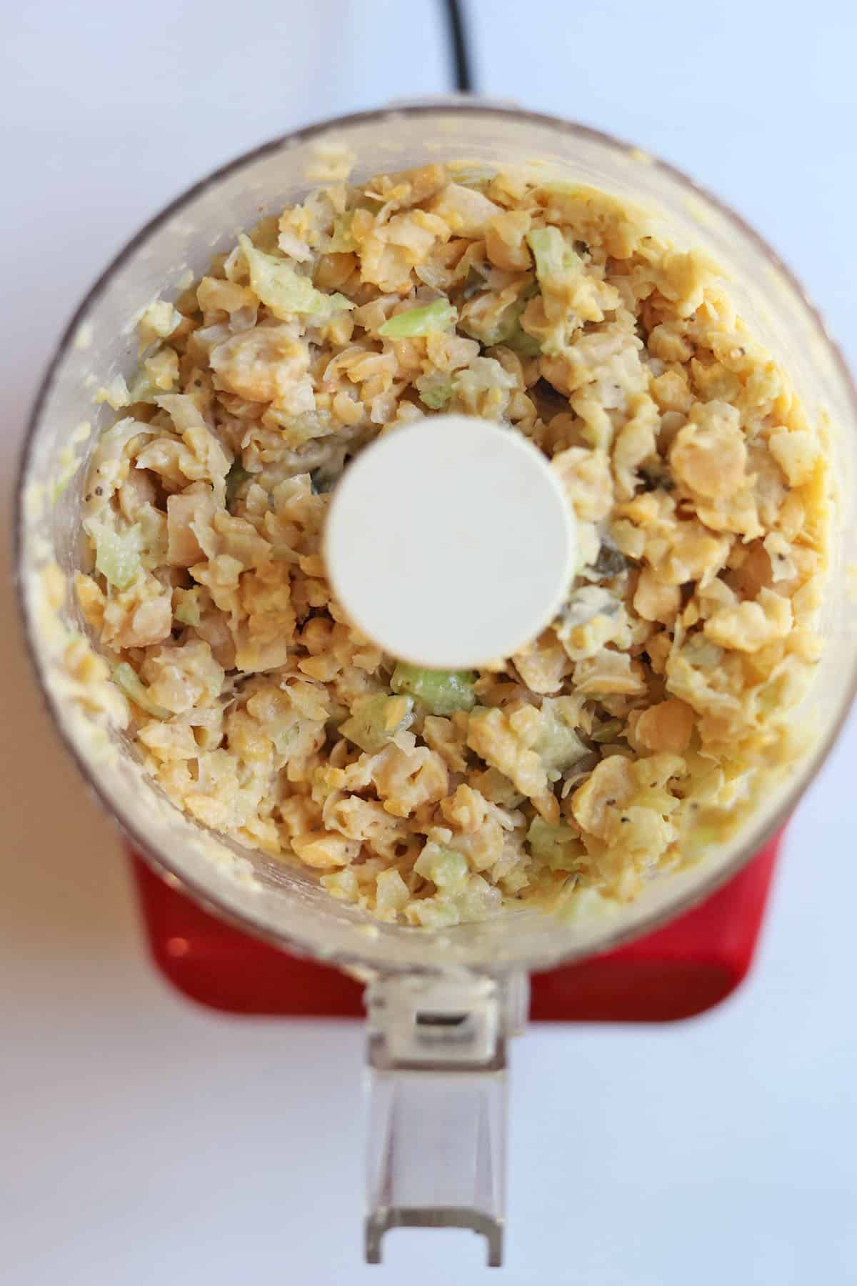 Blended chickpea salad in food processor container.