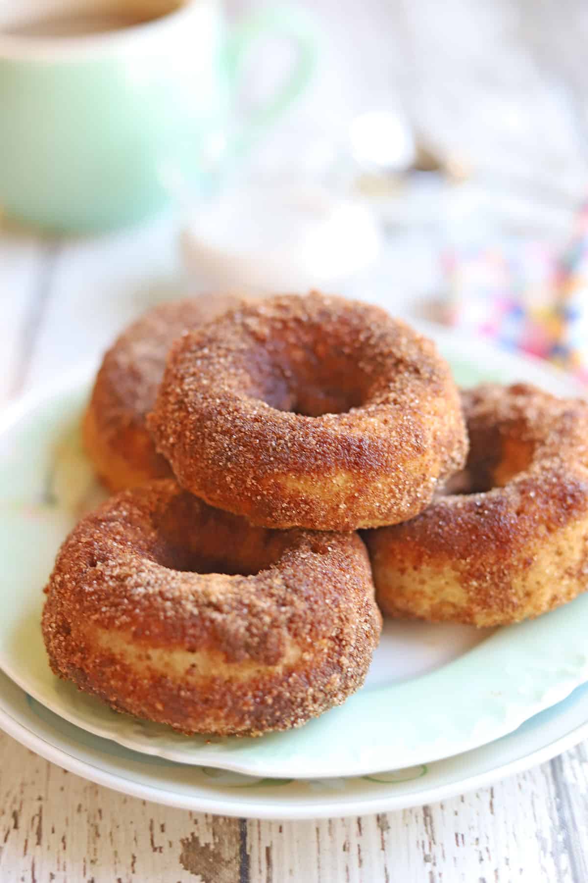 Stack of cinnamon donuts on a plate.