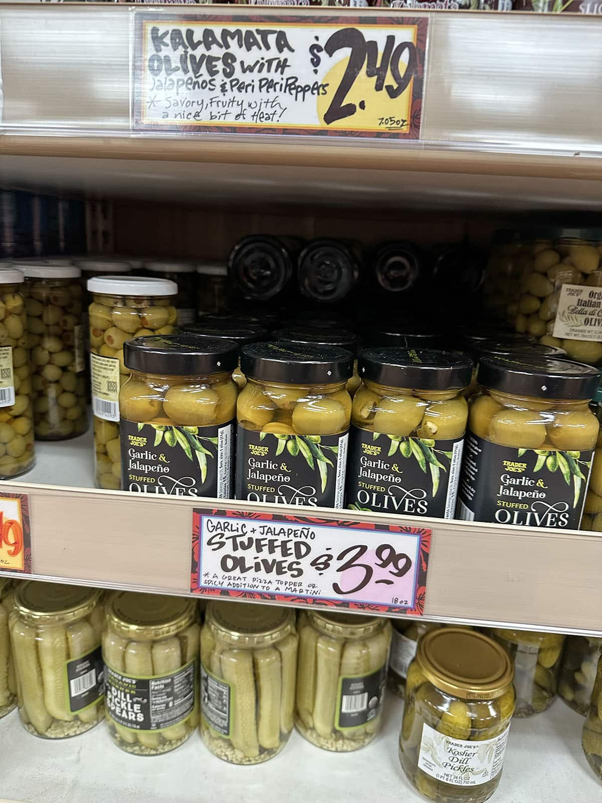 Jars of garlic and jalapeno stuffed olives on the shelf at Trader Joe's.