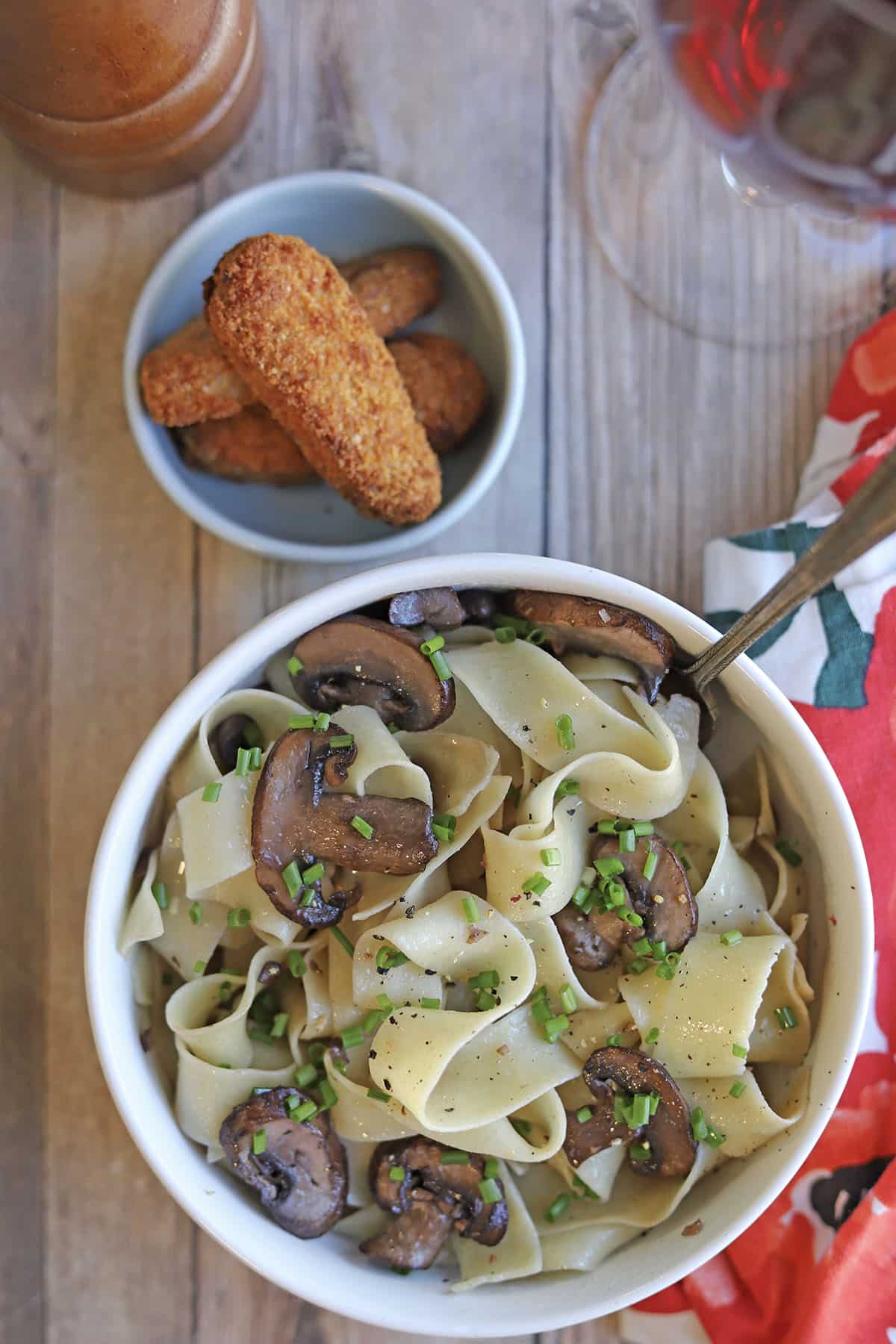 Bowl of vegan pappardelle with mushrooms by vegan chick'n strips.