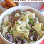 Text overlay: Vegan garlic butter noodles pin. Bowl of pappardelle with mushrooms.