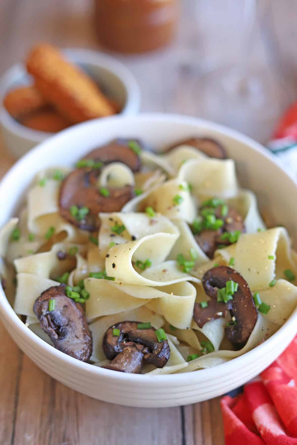 Bowl of vegan buttered noodles with red wine mushrooms.