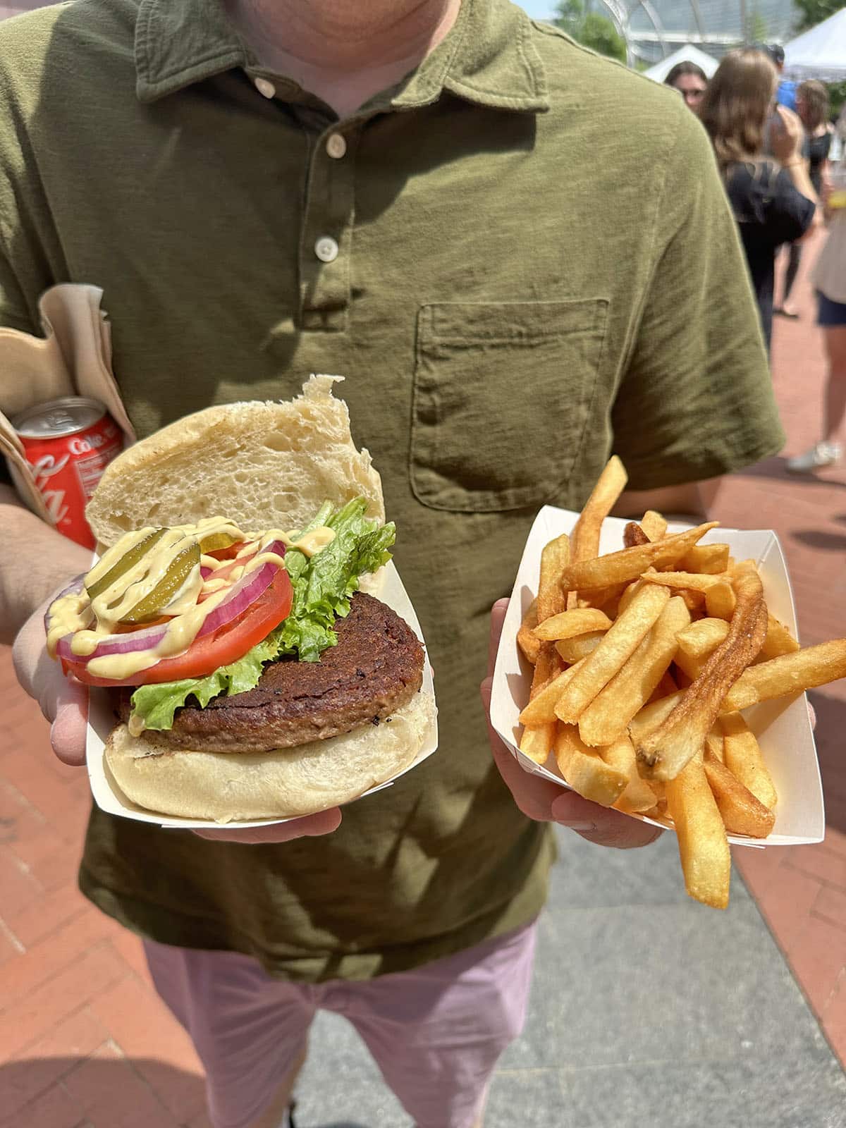 Hands holding Impossible Burger and fries from Top Bun in Des Moines, Iowa.