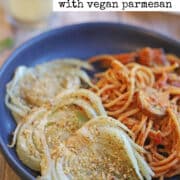 Text overlay: Roasted fennel with vegan parmesan. Close-up of roasted fennel by pile of spaghetti.