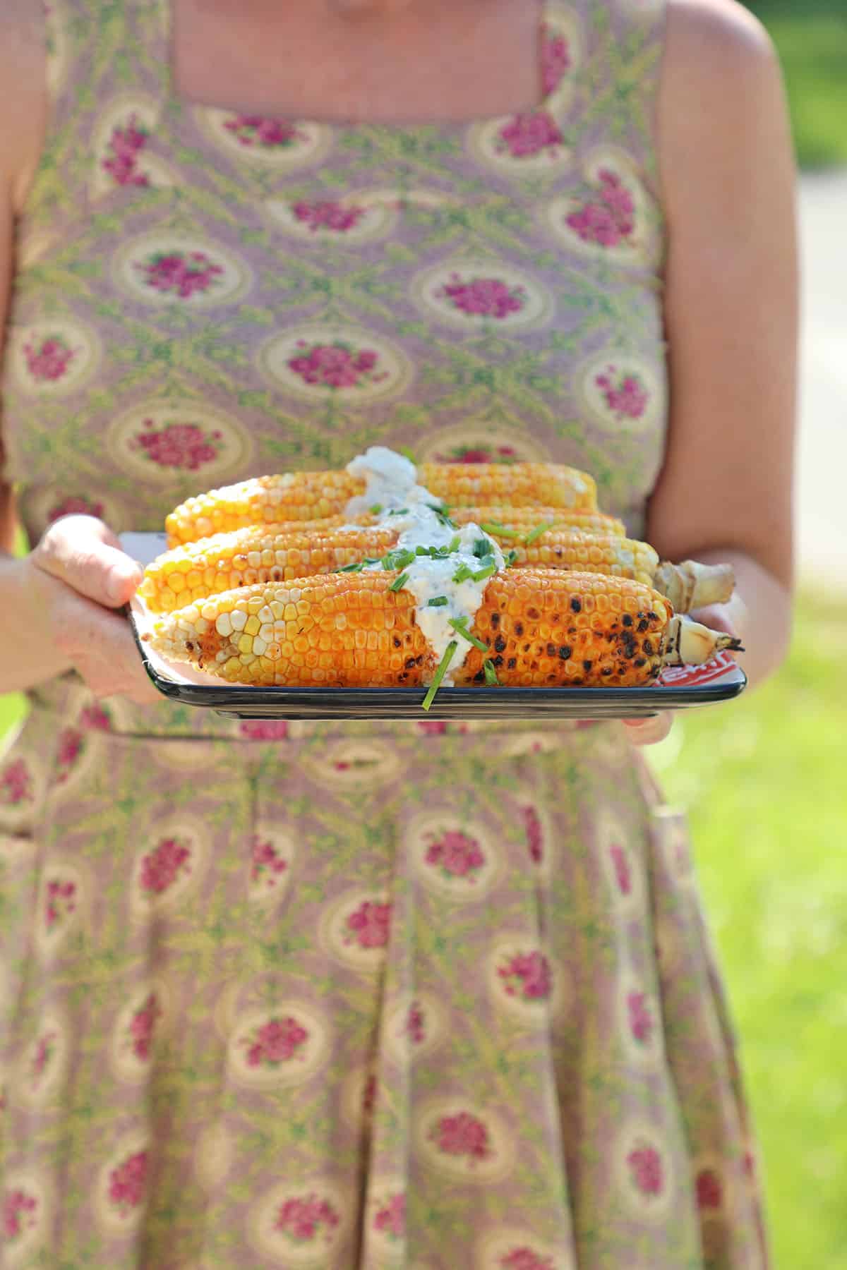 Platter of buffalo corn with vegan blue cheese being held.