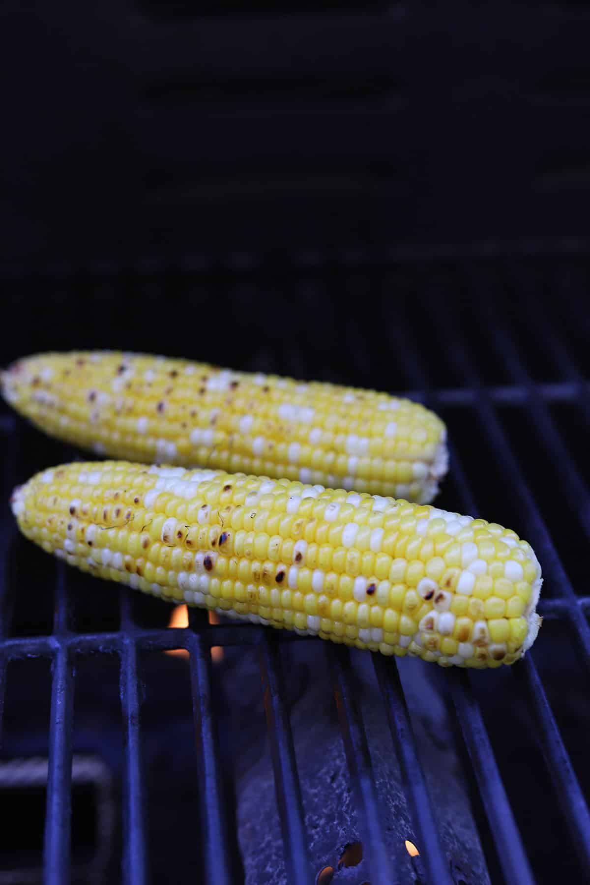 Ears of corn on grill grate.