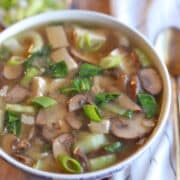 Text overlay: Vegan miso soup pin. Bowl of miso soup with lots of mushrooms, bok choy, and scallions.