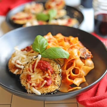 Vegan eggplant parmesan in bowl of pasta.