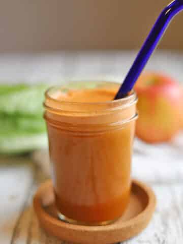 Bright orange glass of carrot apple juice blend.