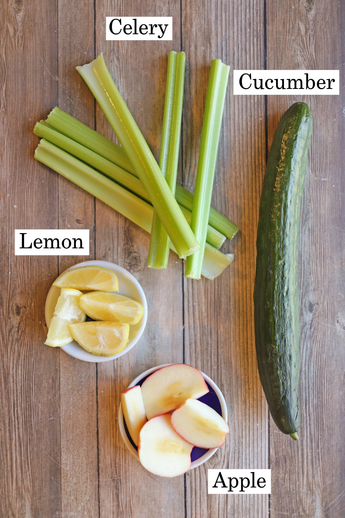 Labeled ingredients for celery and cucumber juice with lemon and apple.