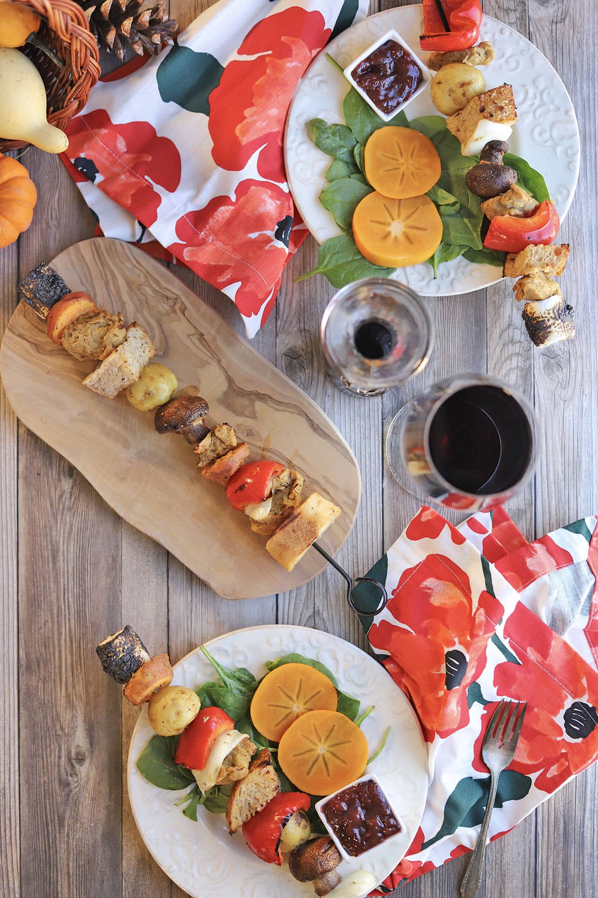 Vegan kebabs on table with wine and colorful napkins.