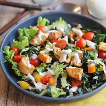 Croutons on top of salad with ranch dressing.