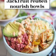 Text overlay: cadryskitchen.com, jackfruit reuben nourish bowls. Light blue bowl filled with potatoes, sauerkraut, corned beef jackfruit, and avocado.