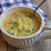 Cheesy vegan cauliflower cheddar soup with carrots in bowl.
