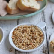 Dukkah nut and seed blend on plate by sliced bread.