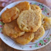 Vegan beer battered fried green tomatoes on floral plate.