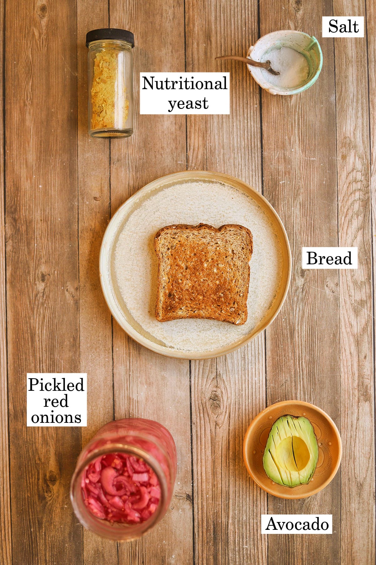 Labeled ingredients for vegan avocado toast with pickled red onions.