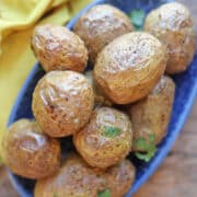 Crispy air fryer baby potatoes on blue plate.