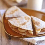 Peanut butter banana quesadilla on orange plate.
