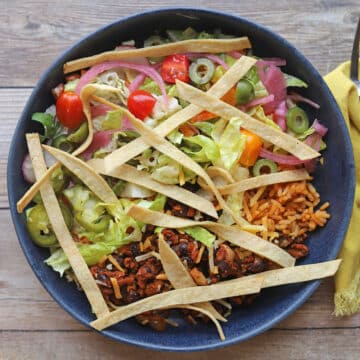 Crunchy air fryer tortilla strips garnishing a vegan burrito bowl.