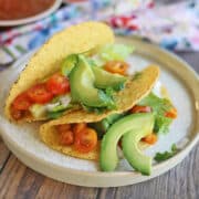 Chickpea tacos in crunchy shells with sliced avocado and cilantro.