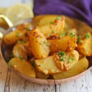 Greek lemon potatoes with chives and garlic in serving dish.