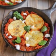Vegan shakshuka with eggy tofu in cast iron skillet and dairy-free feta.
