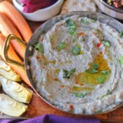 Creamy air fryer baba ganoush in serving dish with oil and cilantro.