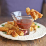 Vegan shrimp made with hearts of palm by cocktail sauce in glass.
