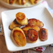 Fried sweet plantains with caramelized edges on white plate.
