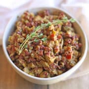 Easy olive tapenade in bowl garnished with fresh thyme.