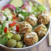 Air fryer falafel in bowl with olives and salad.