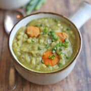 Vegan split pea soup with carrots and barley in bowl with handle.