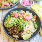 Vegan burrito bowl with lentil taco meat, guacamole, rice, and salad.