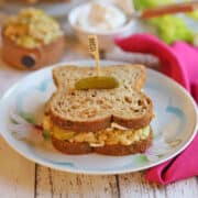 Vegan tuna salad sandwich with chickpeas on plate with cornichon.