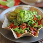 Vegan taco salad in baked tortilla bowl with jalapenos and guacamole.