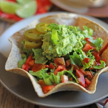Vegan taco salad in baked tortilla bowl with jalapenos and guacamole.