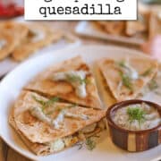 Text overlay: cadryskitchen.com, vegan pierogi quesadilla. Quesadilla with pierogi fillings on plate with yogurt ranch dipping sauce.