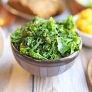 Broccolini and kale side dish in small purple bowl.