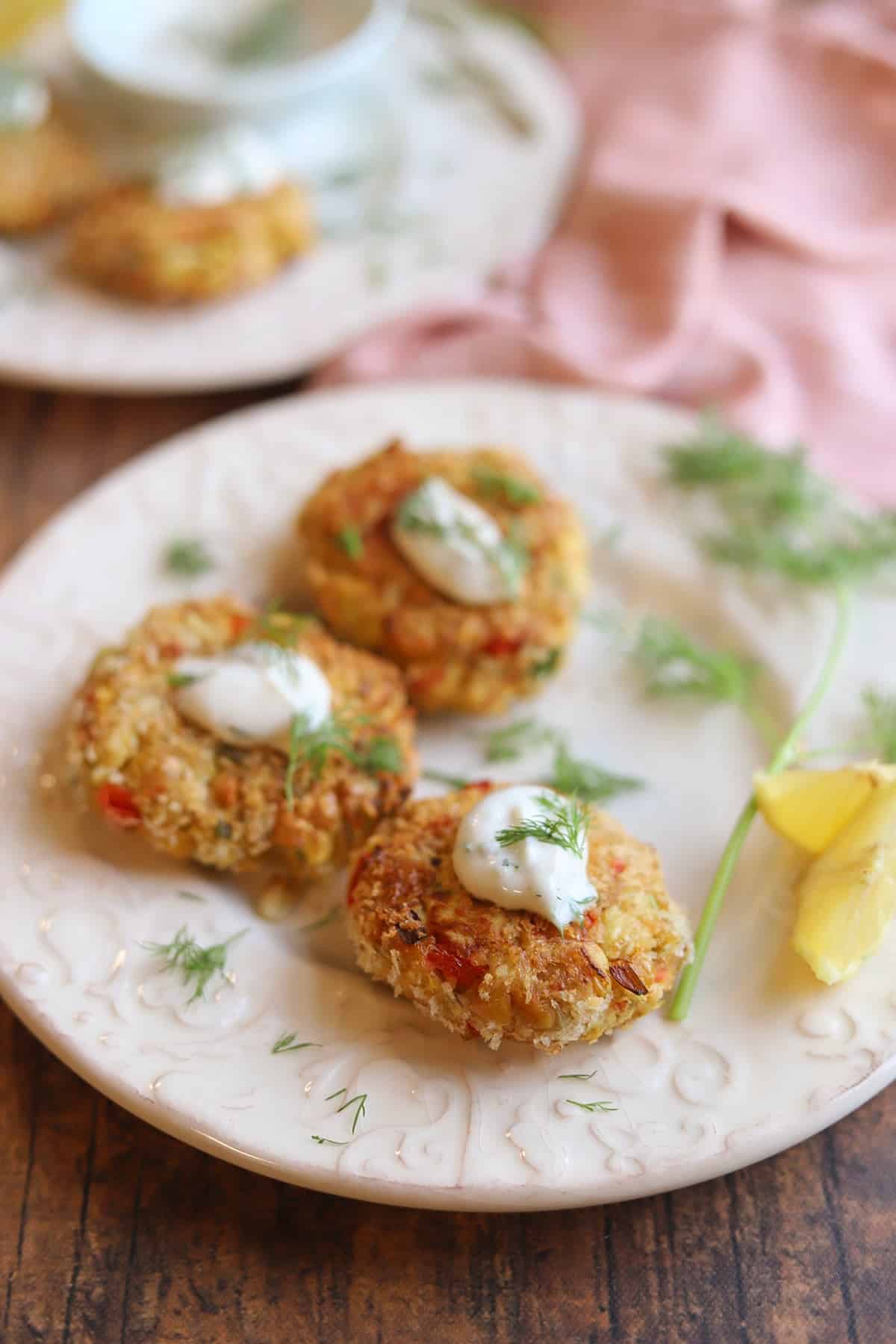 Plate with vegan crab cakes and fresh dill garnish.