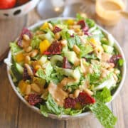 Salad with blood oranges and peanut dressing in bowl.