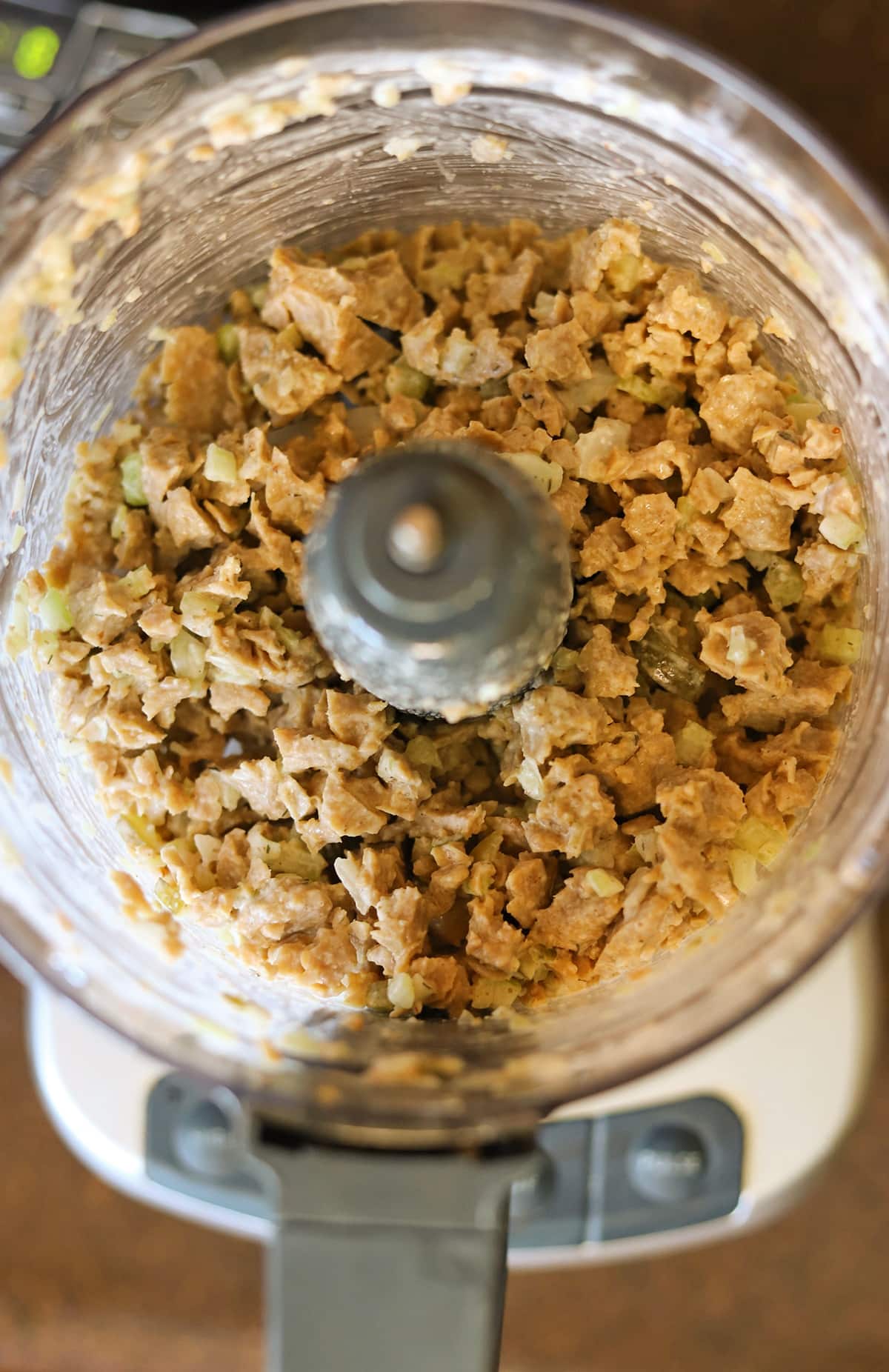 Vegan chicken salad in food processor after being broken up into small pieces.