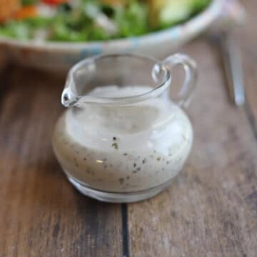 Vegan blue cheese dressing in small glass pourer.