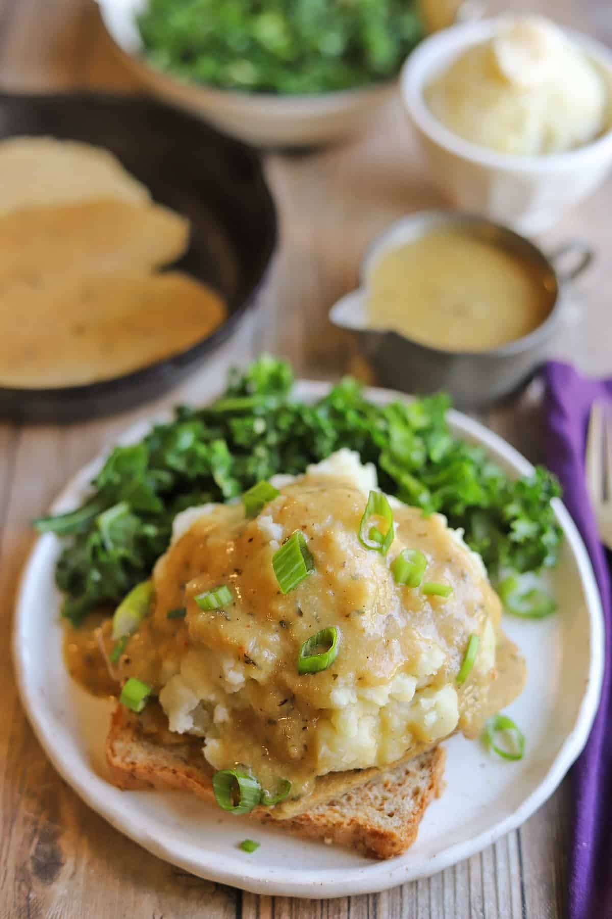 Hot open faced sandwich with turkey seitan, mashed potatoes, gravy, and kale.