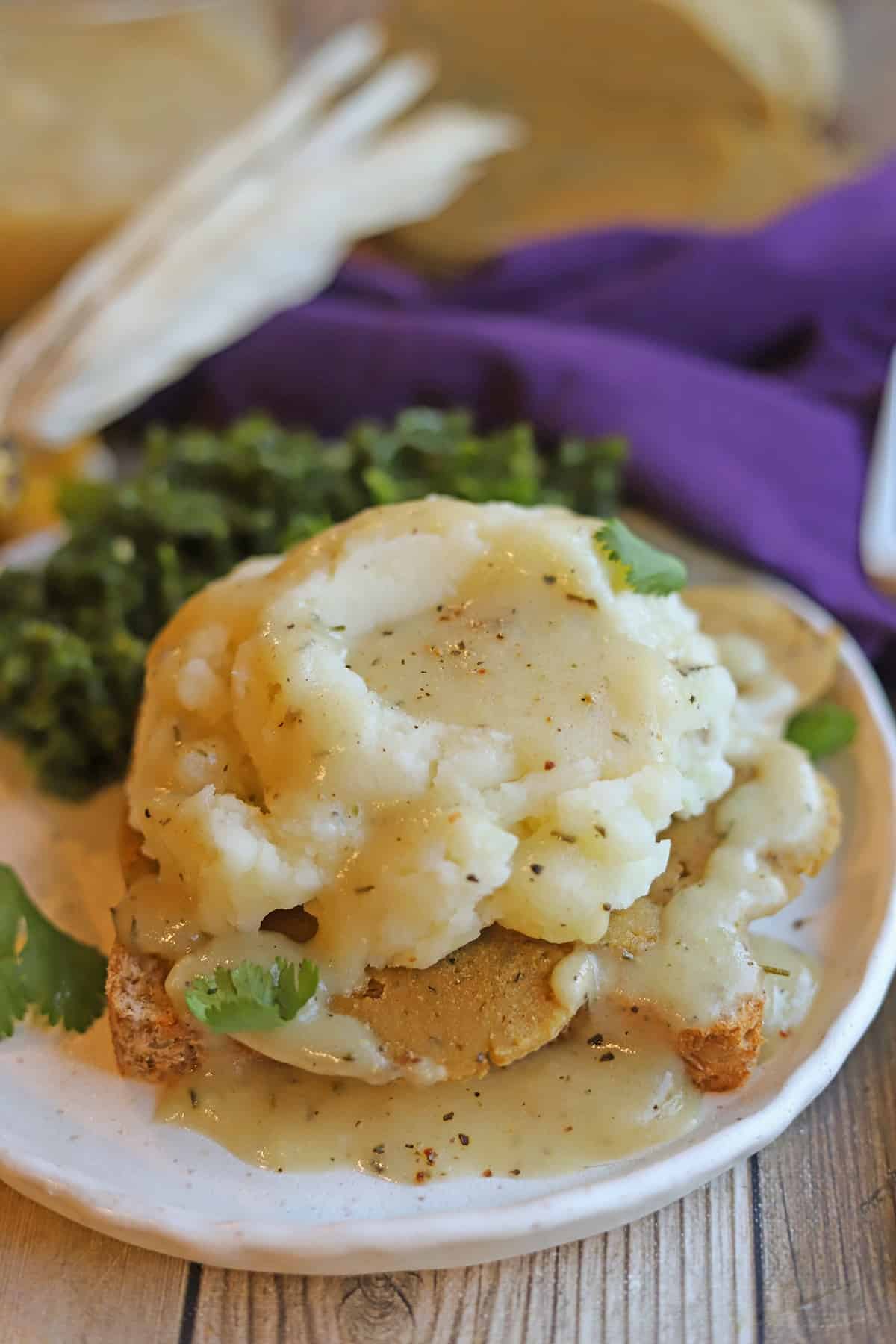 Mashed potatoes with gravy over turkey seitan on plate.