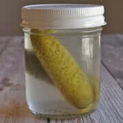 Pickles in jar of vodka, infusing flavor.