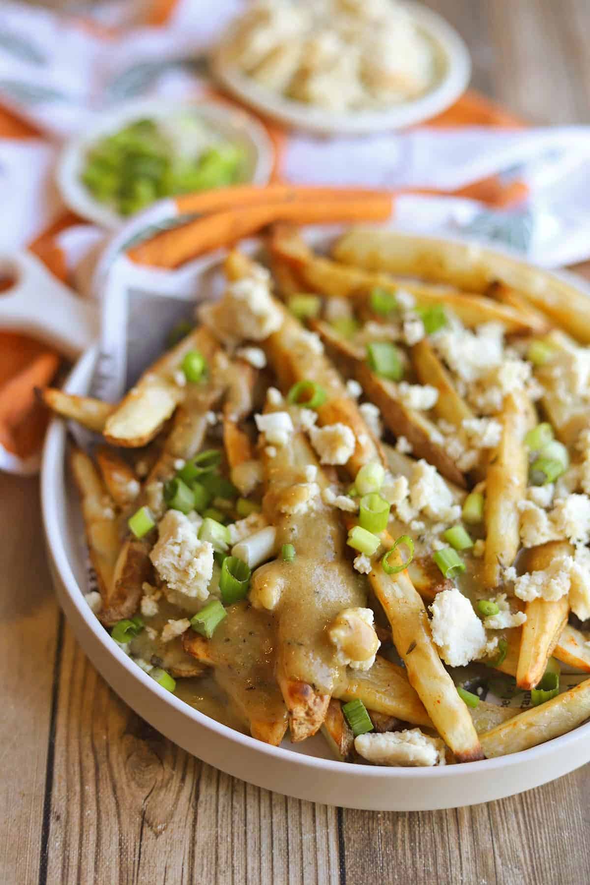 Vegan poutine appetizer with gravy and dairy-free almond feta cheese.