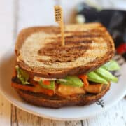 Bulgogi tofu sandwich with kimchi and avocado on marbled rye with "vegan" spear.